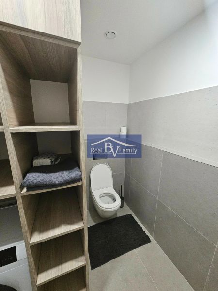 PRENAJATÉ - PRENÁJOM, BOTTOVA, STARÉ MESTO - 2 IZBOVÝ BYT - Kúpeľňa v 2-izbovom byte s toaletou, bielymi stenami a úložnými priestormi v drevenom dekore.