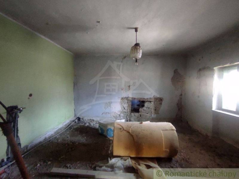 NOVÁ NIŽŠIA CENA ! Priestranný rodinný dom v pôvodnom stave v malej de - Izba v rodinnom dome v Brusníku s poškodenými stenami a rozobratou podlahou.