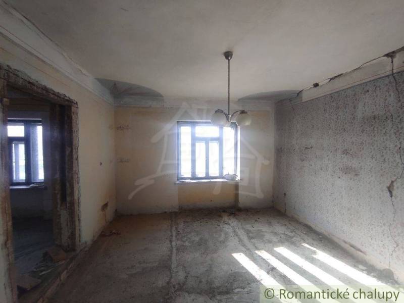 NOVÁ NIŽŠIA CENA ! Priestranný rodinný dom v pôvodnom stave v malej de - Interiér rodinného domu ukazuje prázdnu miestnosť s oknom a svetlami.