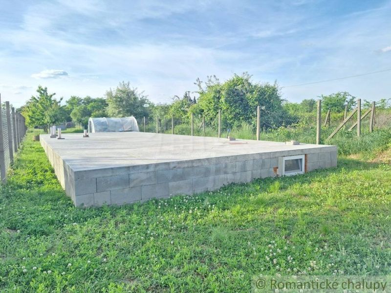 Rovinatý pozemok so základovou doskou na okraji podunajskej dedinky Mo