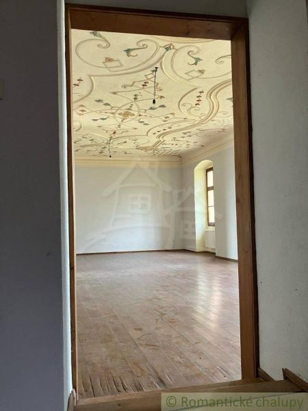 Rekonštruovaný barokový kaštieľ s kaplnkou a rozsiahlym parkom v Trávn - Interiér Zvláštnej nehnuteľnosti s ozdobným stropom a podlahou s dreveným dekorom.