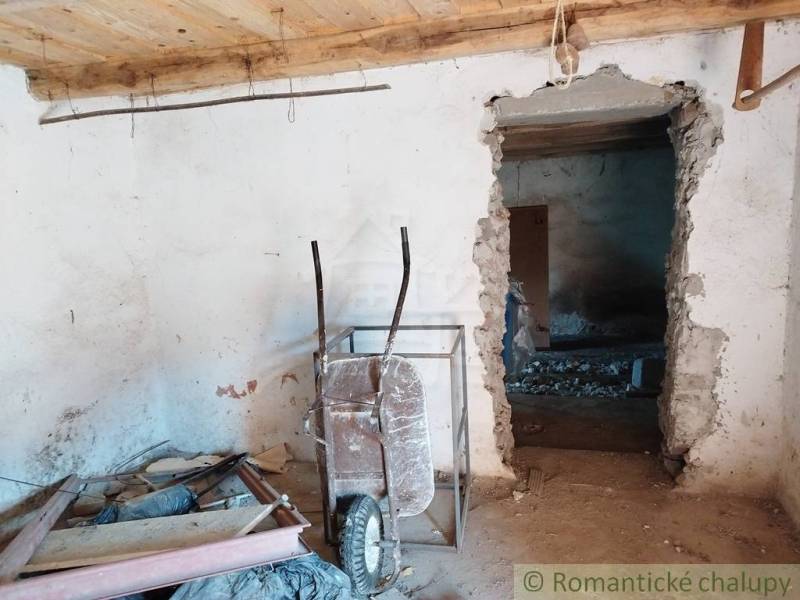 Veľký, vyše 4,5Ha slnečný pozemok s chalupou v strede, na lazoch, pri  - Interiér chaty s fúrikom, stavebný neporiadok a biele steny v Hrušove.