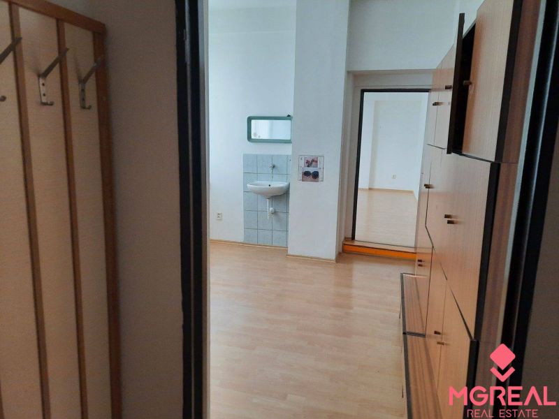Prenájom kancelárií 21 m2 v centre Trnavy - Kancelárie s podlahou s dreveným dekorom, umývadlom a nábytkom.