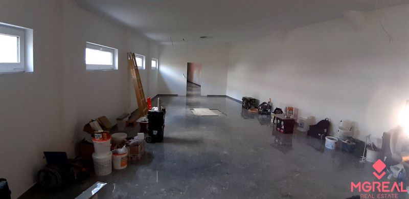 Priestor do prenájmu v centre Topoľčian - Priestranný interiér v obchodných priestoroch s množstvom náradia a materiálu na podlahe.