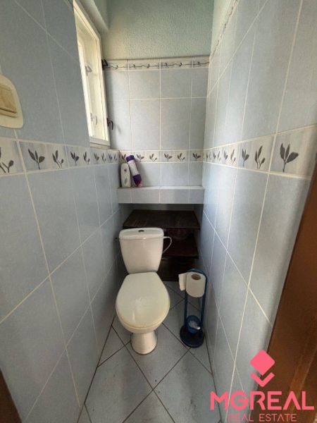 Rodinný dom Solčany - Kúpeľňa v rodinnom dome s toaletou, modré obklady, praktické úložné priestory.