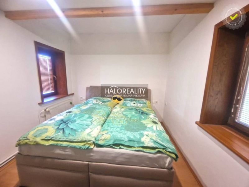 Predaj, rodinný dom Prievidza - Spálňa v rodinnom dome s posteľou a podlahou s dreveným dekorom.