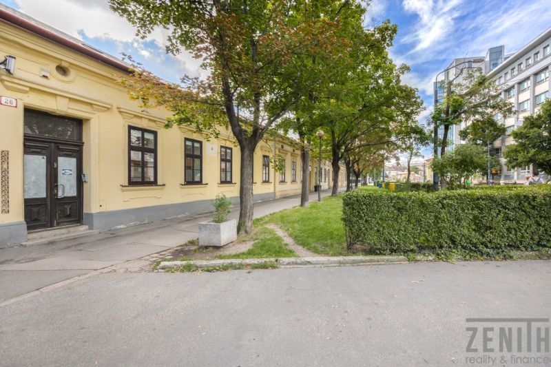 NA PREDAJ - Historický dom s pozemkom v srdci Bratislavy  - Rodinný dom na Radlinského ulici v Bratislave s upravenou zeleňou a chodníkom.