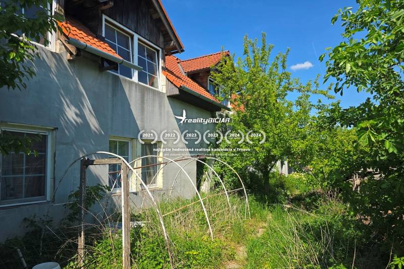 NOVÁ CENA - investičná príležitosť v obci Bíňovce - Rodinný dom na ulici Bíňovce v Bíňovciach, zarastená záhrada, konštrukcie v popredí.