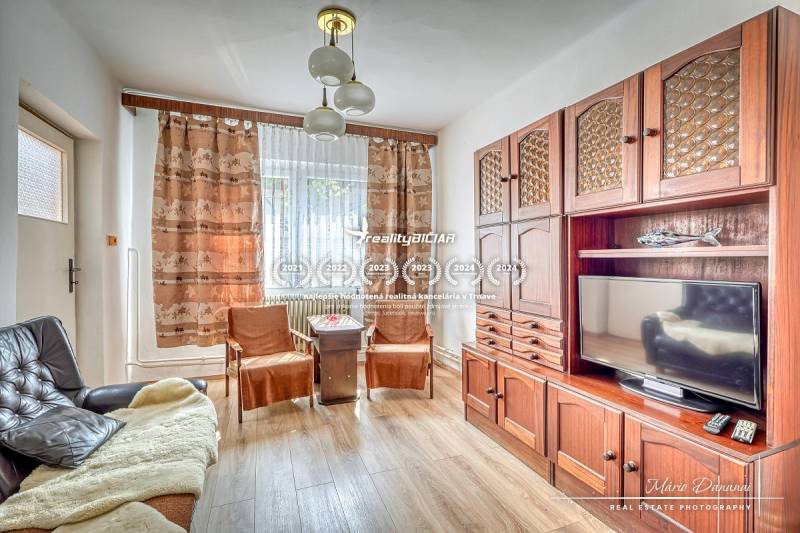 VÝRAZNÁ ZĽAVA 4-izbový rodinný dom na Kopánke v Trnave - Obývacia izba s drevenou zostavou, gaučom a televízorom v rodinnom dome.