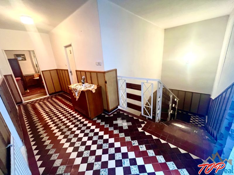 Rodinný dom s veľkým pozemkom - Turňa nad Bodvou - Chodba so vzorovanou dlažbou, dreveným obložením a schodiskom v rodinnom dome.
