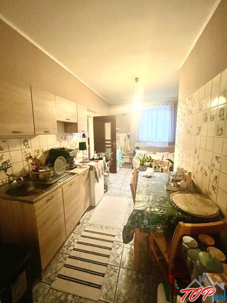 Rodinný dom s veľkým pozemkom - Turňa nad Bodvou - Kuchyňa v rodinnom dome s kuchynskou linkou, jedálenským stolom a keramickými kachličkami.