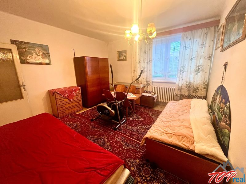 Rodinný dom s veľkým pozemkom - Turňa nad Bodvou - Izba v rodinnom dome s nábytkom, kobercami a cvičebným strojom.
