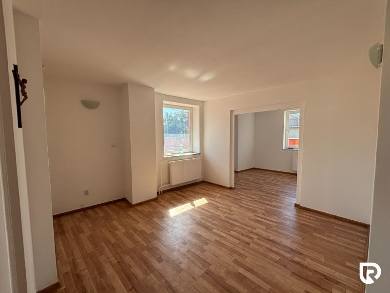 6-izbový rodinný dom s pozemkom 2218m2  | Horňany - Interiér rodinného domu s podlahou s dreveným dekorom, bielymi stenami a oknami.