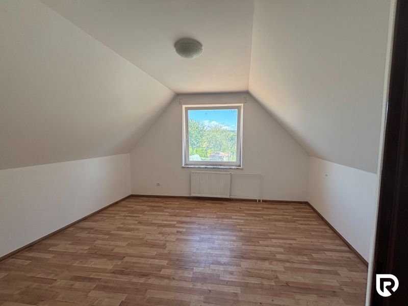 6-izbový rodinný dom s pozemkom 2218m2  | Horňany - Podkrovná izba s oknom, podlaha s dreveným dekorom, rodinný dom.