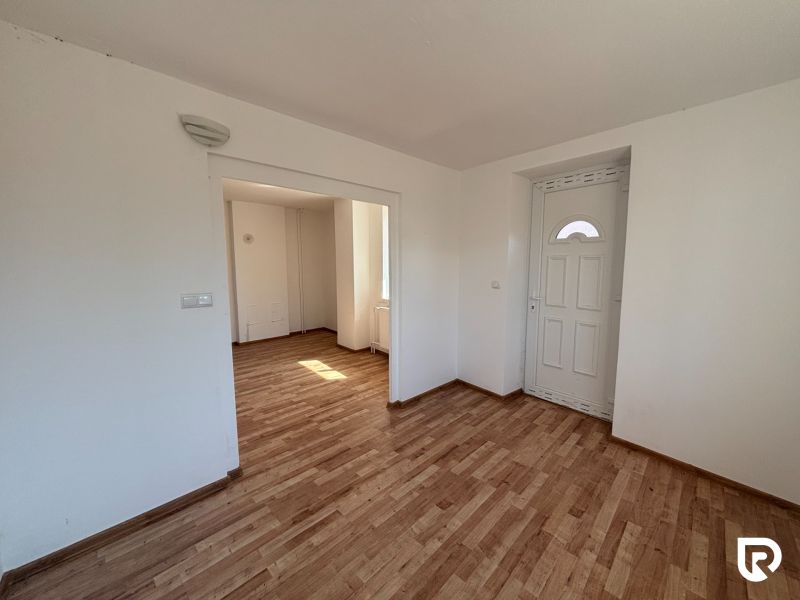 6-izbový rodinný dom s pozemkom 2218m2  | Horňany - Interiér rodinného domu s podlahou s dreveným dekorom, bielymi stenami a dverami.