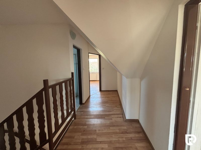6-izbový rodinný dom s pozemkom 2218m2  | Horňany - Chodba s podlahou s dreveným dekorom v rodinnom dome, schodisko, dvere a steny.