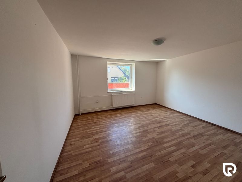 6-izbový rodinný dom s pozemkom 2218m2  | Horňany - Priestranná izba s podlahou s dreveným dekorom v rodinnom dome, svetlo preniká cez veľké okno.