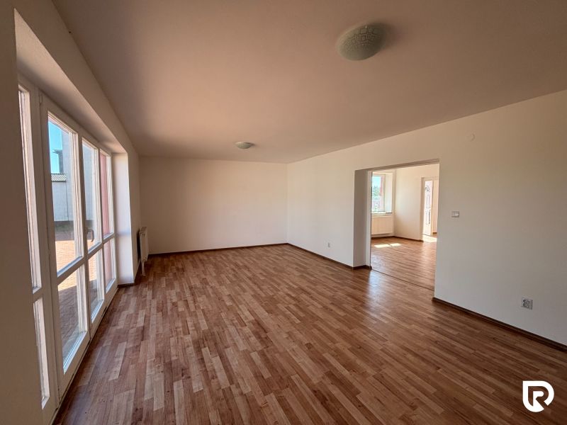 6-izbový rodinný dom s pozemkom 2218m2  | Horňany - Priestranný interiér rodinného domu s veľkými oknami a podlahou s dreveným dekorom.
