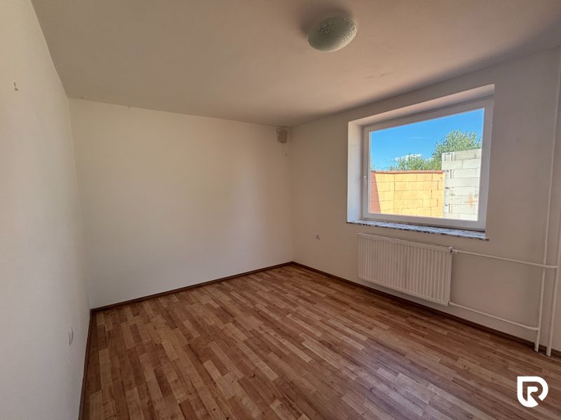 6-izbový rodinný dom s pozemkom 2218m2  | Horňany - Izba s bielymi stenami a podlahou s dreveným dekorom v rodinnom dome.