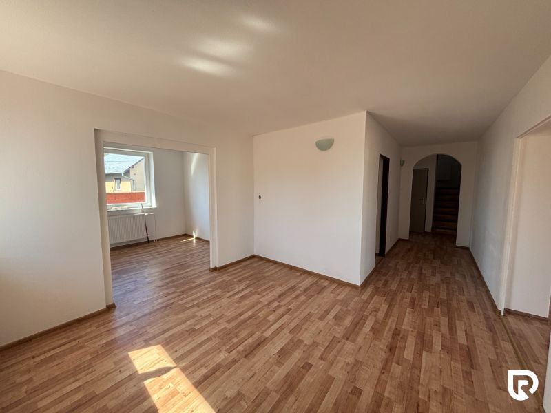 6-izbový rodinný dom s pozemkom 2218m2  | Horňany - Interiér rodinného domu s podlahou s dreveným dekorom a veľkým oknom.