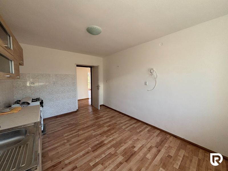 6-izbový rodinný dom s pozemkom 2218m2  | Horňany - Kuchyňa v rodinnom dome s podlahou s dreveným dekorom a bielymi stenami.