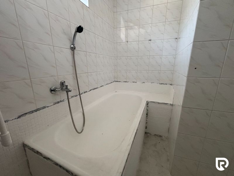 6-izbový rodinný dom s pozemkom 2218m2  | Horňany - Kúpeľňa v rodinnom dome s bielou obkladačkou a vaňou.