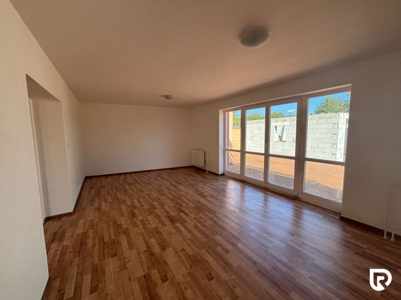 6-izbový rodinný dom s pozemkom 2218m2  | Horňany - Obývacia izba v rodinnom dome s podlahou s dreveným dekorom a veľkými oknami.
