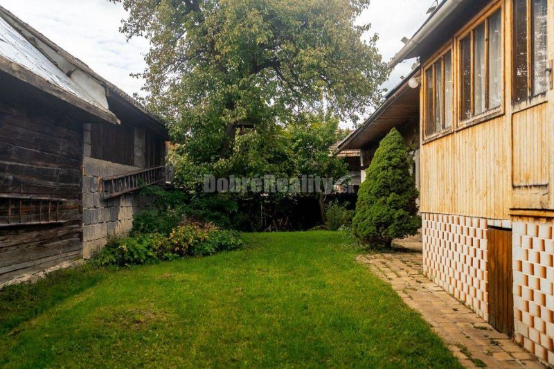 PREDAJ: Drevenica pri Ždiarskom potoku s príjemnou verandou, 135 m2, P - Dvor medzi drevenými chatami v Polomke, obklopený hustou zeleňou a stromami.