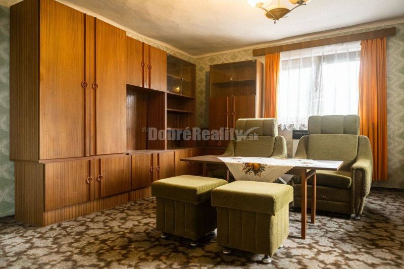 PREDAJ: Drevenica pri Ždiarskom potoku s príjemnou verandou, 135 m2, P - Interiér chaty s retro nábytkom, zelené kreslá, závesy, koberec a drevená stena.
