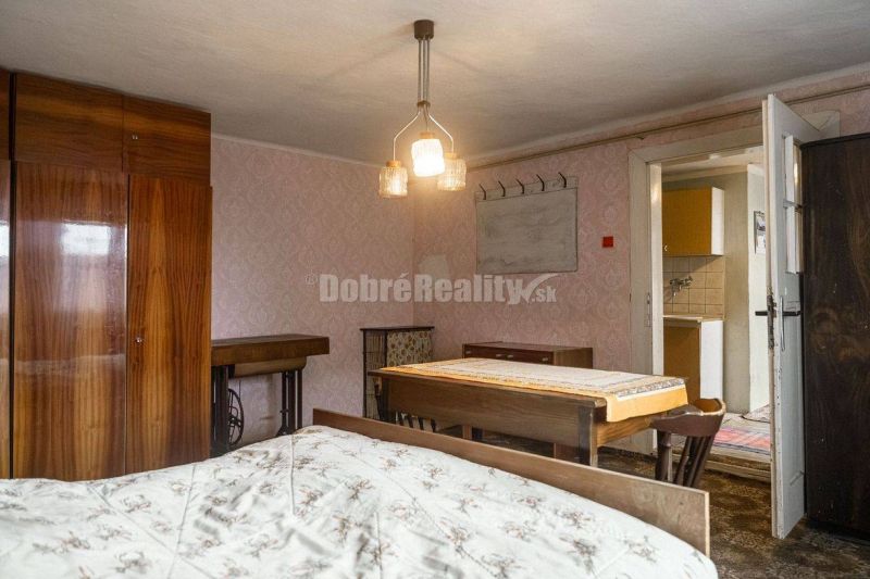 PREDAJ: Drevenica pri Ždiarskom potoku s príjemnou verandou, 135 m2, P - Interiér chaty s drevenými skriňami, stolom a posteľou, vyžaruje útulnú atmosféru.
