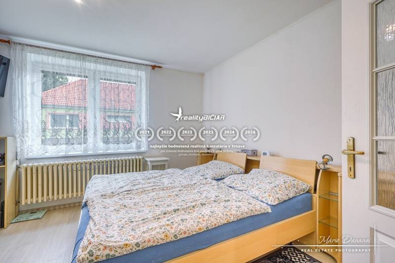 5-izbový rodinný dom s dvomi garážami v obci Špačince - Spálňa v rodinnom dome s veľkým oknom a dvojposteľou.