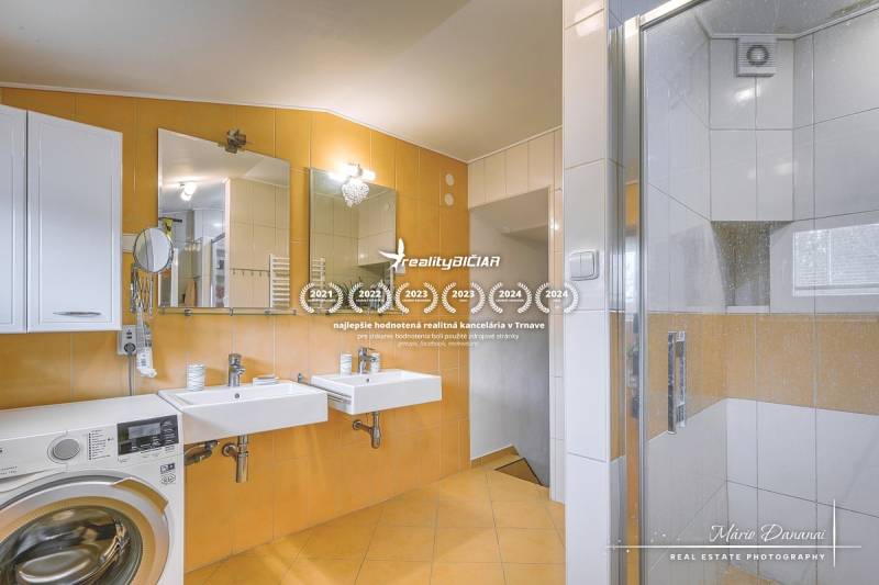 5-izbový rodinný dom s dvomi garážami v obci Špačince - Kúpeľňa v rodinnom dome s dvojitým umývadlom, sprchovým kútom a práčkou.