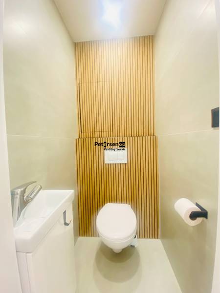 NA PRENÁJOM NOVOZREKONŠTRUOVANÝ 2-IZBOVÝ BYT, UL. ROŽŇAVSKÁ - Toaleta s dreveným dekorom v 2-izbovom byte. Biela sanitárna keramika.