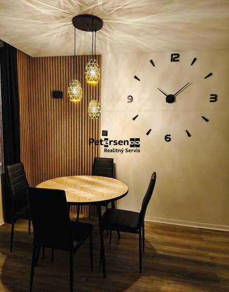 NA PRENÁJOM NOVOZREKONŠTRUOVANÝ 2-IZBOVÝ BYT, UL. ROŽŇAVSKÁ - Jedálenský kút v 2-izbovom byte s kruhovým stolom a podlahou s dreveným dekorom.