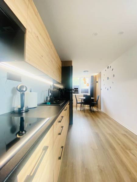 NA PRENÁJOM NOVOZREKONŠTRUOVANÝ 2-IZBOVÝ BYT, UL. ROŽŇAVSKÁ - Kuchyňa s dreveným dekorom a jedálenským kútom v 2-izbovom byte.