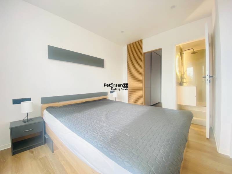 NA PRENÁJOM NOVOZREKONŠTRUOVANÝ 2-IZBOVÝ BYT, UL. ROŽŇAVSKÁ - Svetlá spálňa s podlahou s dreveným dekorom, dvojlôžkom a vstavanou skriňou, 2-izbový byt.