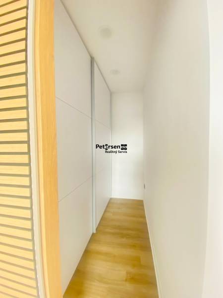 NA PRENÁJOM NOVOZREKONŠTRUOVANÝ 2-IZBOVÝ BYT, UL. ROŽŇAVSKÁ - Chodba s podlahou s dreveným dekorom a vstavanou skriňou v 2-izbovom byte.