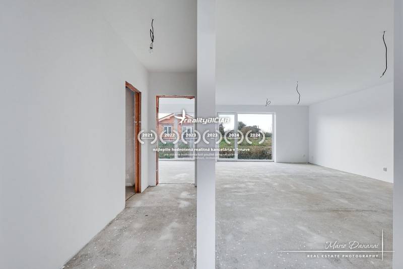 Novostavba 4-izbového rodinného domu v obci Slov.Nová Ves - Prázdny interiér v rodinnom dome s pohľadom na veľké okno a zádverie.