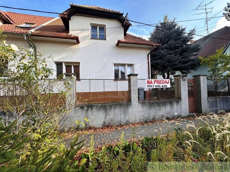 Starý dom s dušou – čaká na nový život v jednej z najkrajších ulíc Nov - Rodinný dom v Nových Zámkoch s červenou strechou a oplotenou záhradou na predaj.