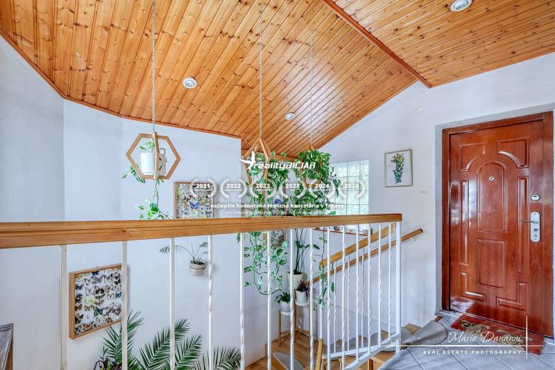 7-izbový rodinný dom s úžasným výhľadom v prestížnej lokalite Devín - Vstupná hala v chate s dreveným stropom a bohatou zeleňou, podlaha s dreveným dekorom.