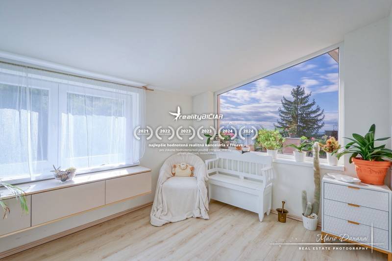 7-izbový rodinný dom s úžasným výhľadom v prestížnej lokalite Devín - Svetlá izba v chate s množstvom rastlín a podlahou s dreveným dekorom.