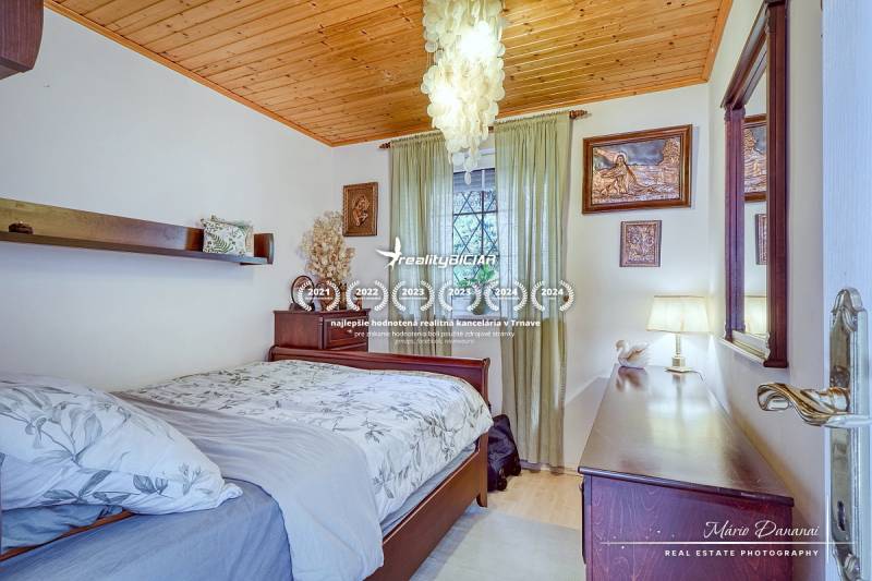 7-izbový rodinný dom s úžasným výhľadom v prestížnej lokalite Devín - Spálňa v rodinnom dome s dreveným stropom, lustrami a dekorovanými stenami.