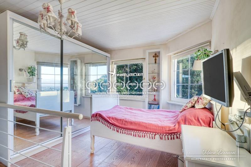 Rekreačná chata s úžasným výhľadom v prestížnej lokalite Devín - Svetlá izba v rodinnom dome s posteľou, zrkadlom a podlahou s dreveným dekorom.