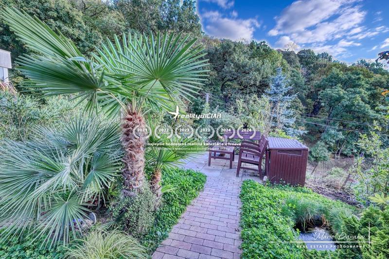 Rekreačná chata s úžasným výhľadom v prestížnej lokalite Devín - Rodinný dom v Bratislave - Devíne s terasou, záhradou a palmou s výhľadom na les.