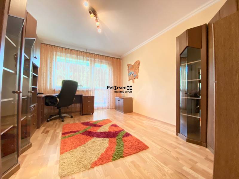 NA PRENÁJOM PRIESTRANNÝ 3-IZBOVÝ BYT V SKVELEJ LOKALITE, UL. SLOBODY - Izba v 3-izbovom byte s pracovným stolom a podlahou s dreveným dekorom.