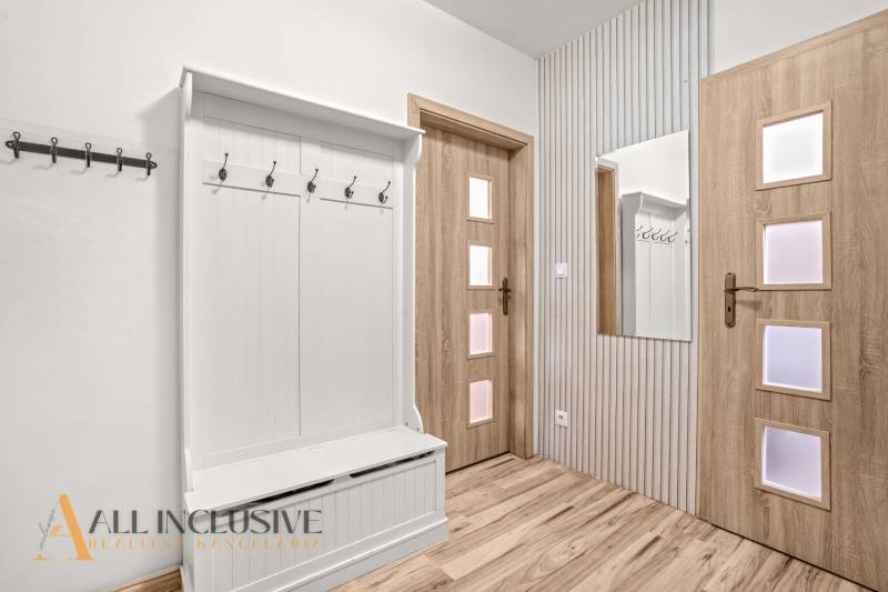 REZERVOVANÉ | NA PREDAJ 3-IZBOVÝ BYT S TERASOU, BLATNÁ NA OSTROVE - Vstupná hala v 3-izbovom byte s vešiakmi, zrkadlom a podlahou s dreveným dekorom.