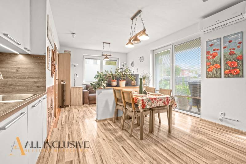 REZERVOVANÉ | NA PREDAJ 3-IZBOVÝ BYT S TERASOU, BLATNÁ NA OSTROVE - Jedáleň v 3-izbovom byte s podlahou s dreveným dekorom a množstvom rastlín.