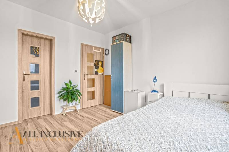 REZERVOVANÉ | NA PREDAJ 3-IZBOVÝ BYT S TERASOU, BLATNÁ NA OSTROVE - Spálňa v 3-izbovom byte s podlahou s dreveným dekorom a jednoduchým zariadením.