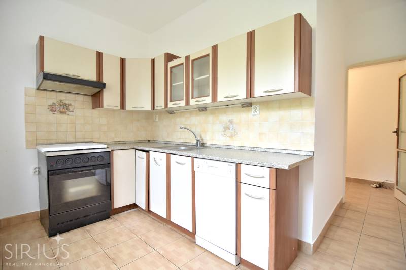 SEČOVSKÁ, 2-i tehlový byt, 56 m2, orientácia V a Z - OBKLOPENÝ ZELEŇOU - Kuchyňa v 2-izbovom byte s bielou linkou a dlažbou.