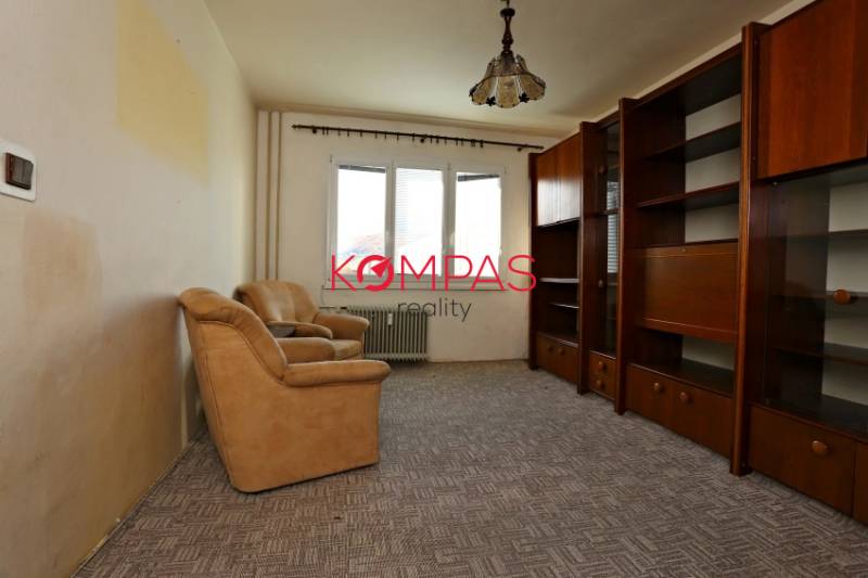 ÚTULNÝ, SVETLÝ 2 IZB.BYT S PRÍJEMNÝM VÝHĽADOM, DETVA - Obývacia izba v 2-izbovom byte so starším nábytkom a kobercom na podlahe.